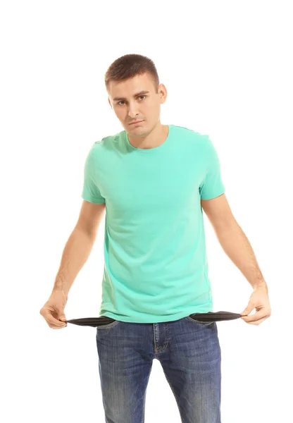 Young man showing his empty pockets on white background — Stock Photo, Image