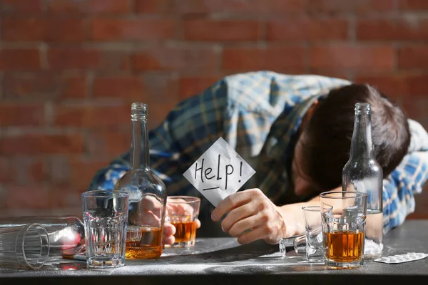 Пьяный Человек Сидит Столом Держит Руках Бумагу Словом Помощь Концепция — стоковое фото