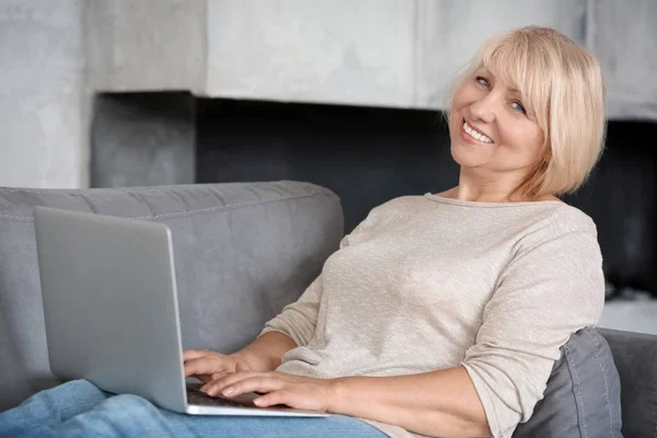 Mulher madura trabalhando no laptop em casa — Fotografia de Stock