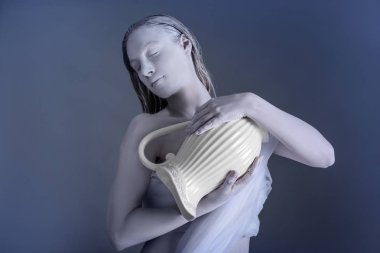 Güzel genç kadın inanılmaz vücut-sanat ile kova olarak gri bir arka plana dayanır. Zodyak işaretleri kavramı