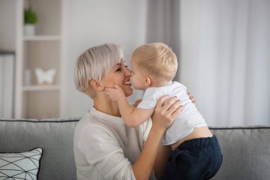 Çekici genç annesi bebeğini evde kanepede ile
