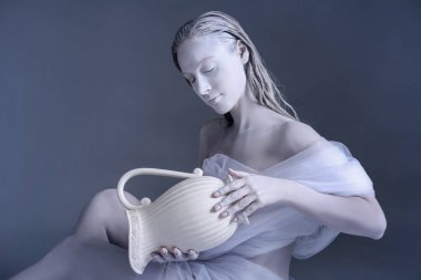 Güzel genç kadın inanılmaz vücut-sanat ile kova olarak gri bir arka plana dayanır. Zodyak işaretleri kavramı