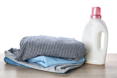 Elbise ve çamaşır yığını beyaz arka plan karşı masada deterjan