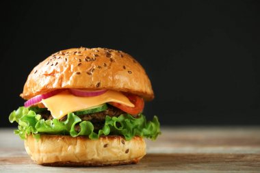 Koyu arka plan karşı ahşap masa lezzetli burger