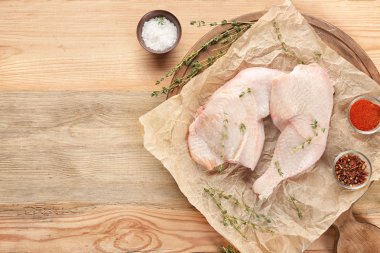 Ahşap arka plan, üstten görünüm üzerinde çiğ tavuk budu ile kurulu