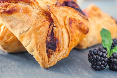 Puf hamur işleri ile böğürtlen ahşap masa, closeup üzerinde