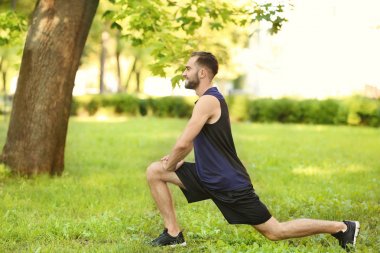 Sportif genç adam dışarıda antrenman yapıyor.