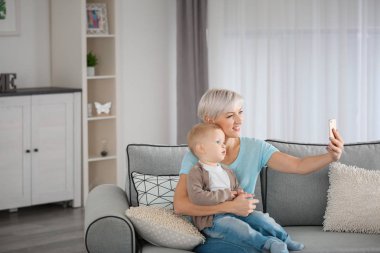 Genç alarak selfie bebeği ile evde anne.