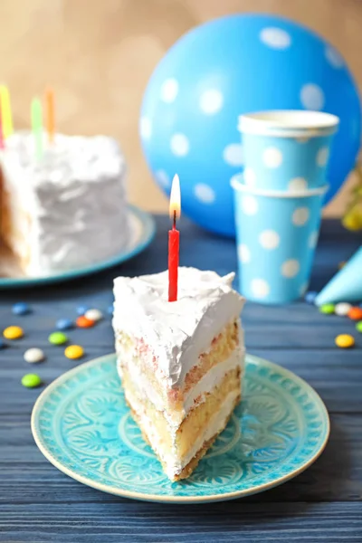 Pedaço de bolo de aniversário com vela na mesa — Fotografia de Stock