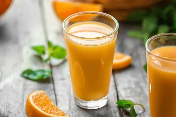 Gläser mit frischem Orangensaft auf dem Tisch — Stockfoto