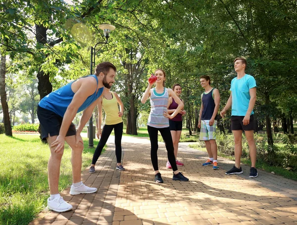 Group of young people resting after running in park — Stock Photo, Image