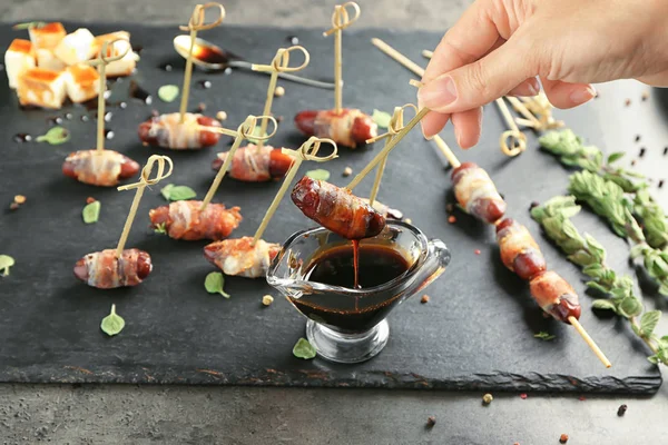 Kvinne Som Dypper Bacon Innpakket Sausenebb Med Saus Bordet – stockfoto