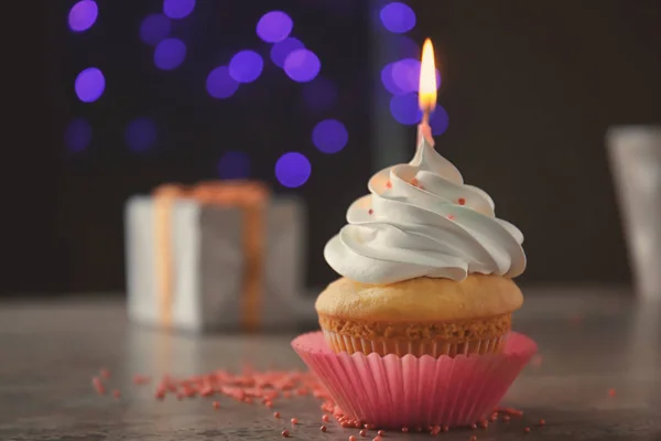 Delicious cupcake with candle on blurred background — Stock Photo, Image