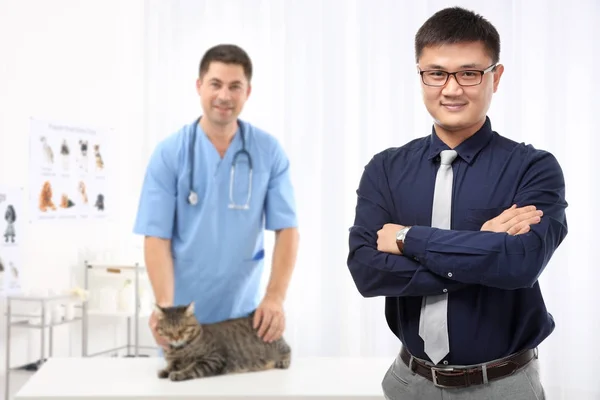 İş ve personel ile veteriner kliniğinde kedi sahibi — Stok fotoğraf