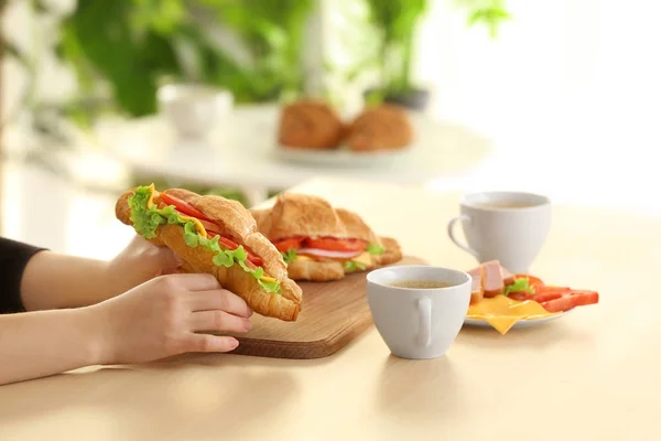 Vrouw Met Heerlijke Croissant Sandwich Binnenshuis — Stockfoto
