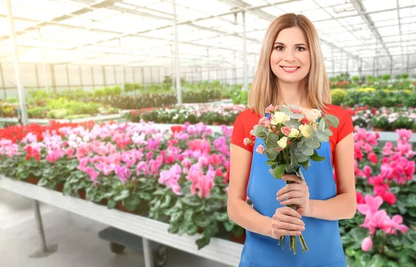 Proprietario di affari floreali con bouquet nella sua serra — Foto Stock