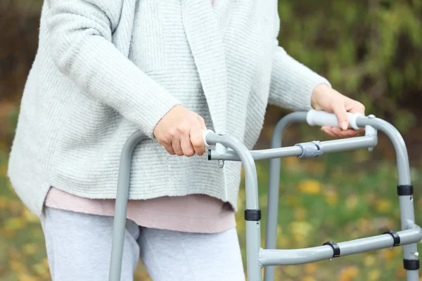 Elderly woman with walking frame outdoors, closeup