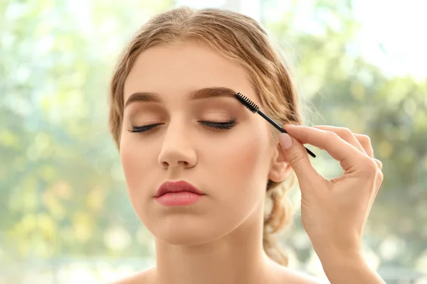 Mujer joven que tiene procedimiento de corrección de cejas en el salón de belleza — Foto de Stock