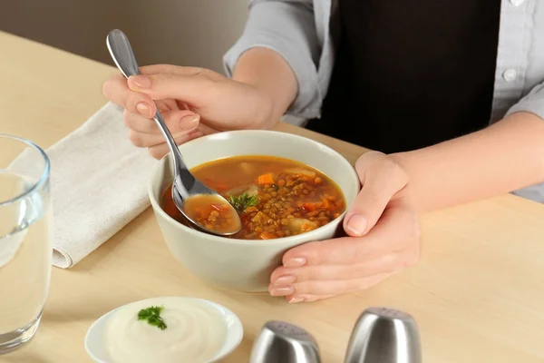 Woman eating tasty lentil soup at table — Stock Photo, Image