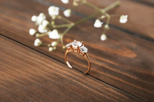 Beautiful engagement ring on wooden background — Stock Photo, Image