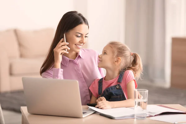 Jeune femme occupée avec sa fille au bureau à la maison — Photo