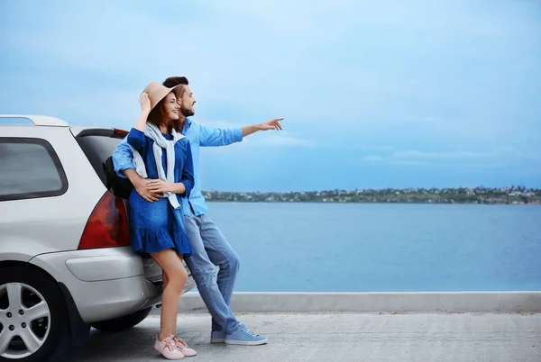 Pareja joven cerca de coche, al aire libre —  Fotos de Stock