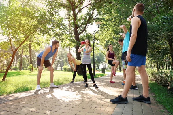 Grupo de jóvenes descansando después de correr en el parque — Foto de Stock