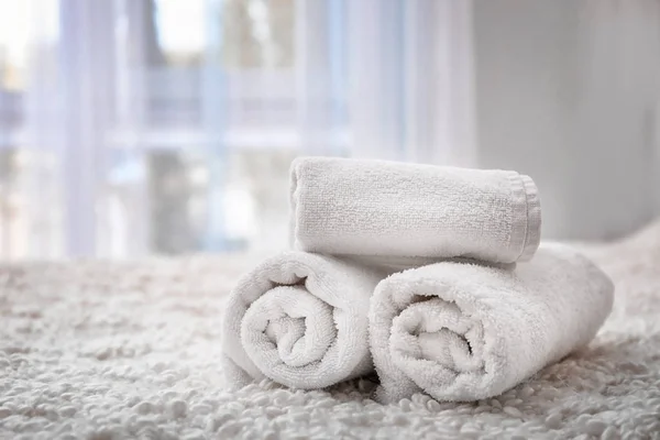 Rolled bath towels on bed in hotel suite — Stock Photo, Image