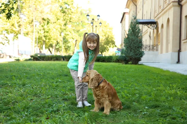 Nettes kleines Mädchen mit lustigem Hund im Freien — Stockfoto