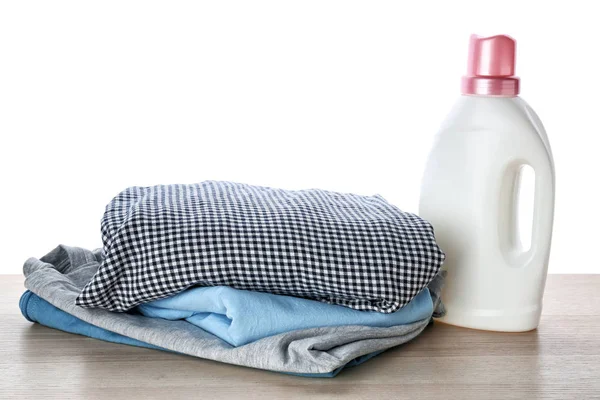 Elbise ve çamaşır yığını beyaz arka plan karşı masada deterjan