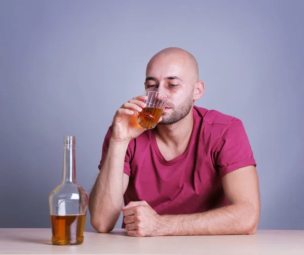 Mann trinkt Whisky am Tisch. Alkoholismus-Konzept — Stockfoto