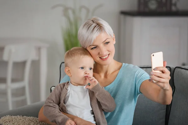 Bevétel-selfie fiatal Anya gyermekével otthon — Stock Fotó