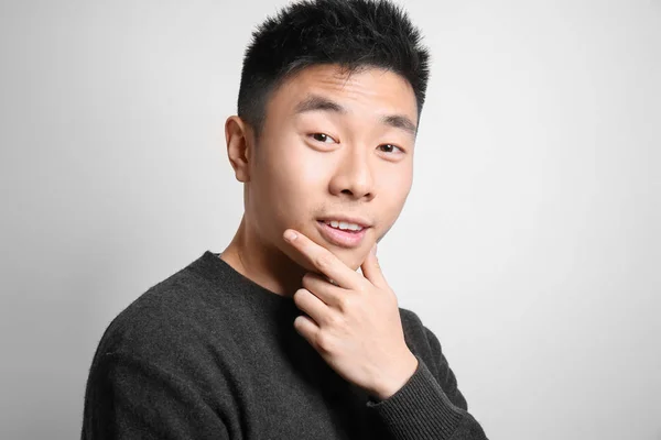 Porträt eines jungen asiatischen Mannes auf hellem Hintergrund — Stockfoto