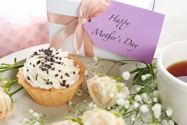 Tasty dessert, flowers and gift for Mother\'s day on tray, closeup