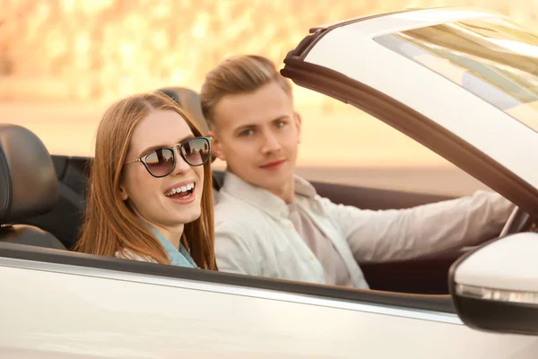 Heureux jeune couple en voiture sur la route — Photo