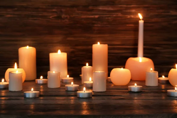 Muchas velas encendidas sobre fondo de madera — Foto de Stock