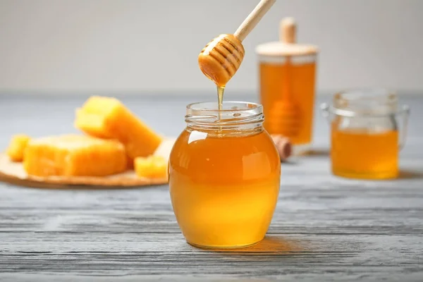 Honig Tropft Aus Holzlöffel Glas Auf Tisch — Stockfoto