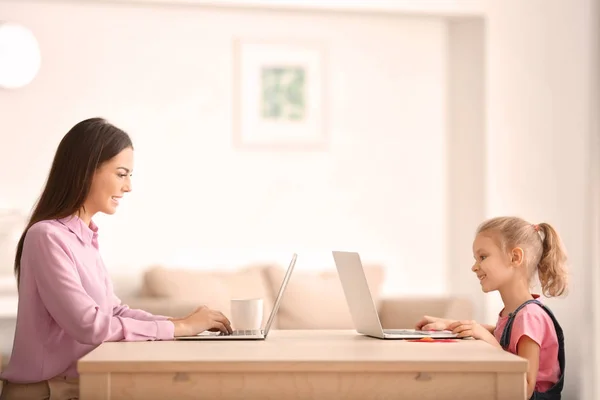 Jovem e sua filha com laptops em casa — Fotografia de Stock