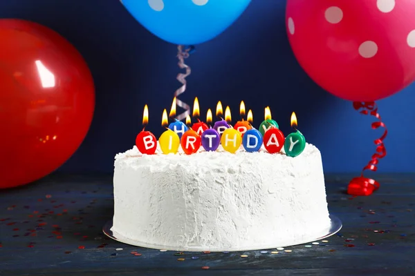 Kuchen mit "Happy Birthday" -Kerzen auf dem Tisch — Stockfoto