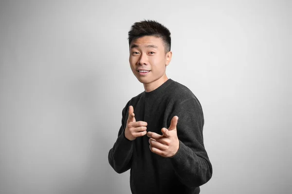 Porträt eines jungen asiatischen Mannes auf hellem Hintergrund — Stockfoto