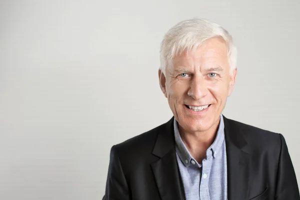 Portrait of mature man in dark suit on light background — Stock Photo, Image