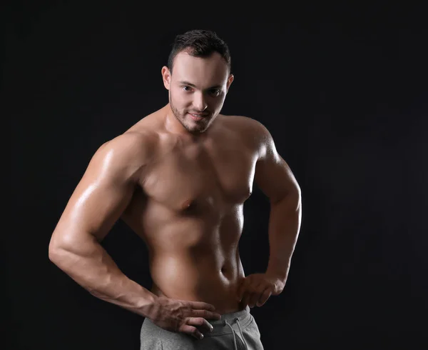 Muskulöser junger Bodybuilder auf dunklem Hintergrund — Stockfoto