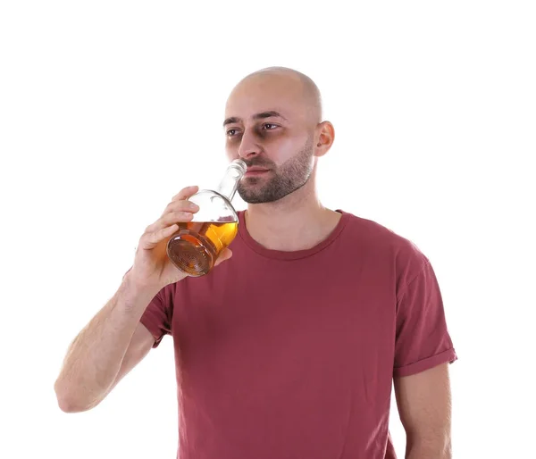Мужчина пьет виски на белом фоне. Концепция алкоголизма — стоковое фото