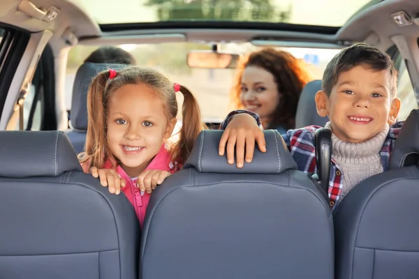 Schattige kinderen met ouders in auto — Stockfoto