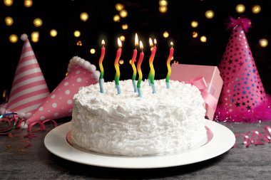 Doğum günü pastası ve mum ışıkları arka plan karşı masada yemek