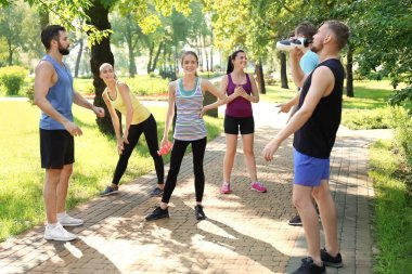 Bir grup genç insan parkta çalıştırdıktan sonra dinlenme