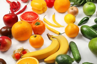 Meyve ve sebze gökkuşağı renkleri beyaz zemin üzerine yapılmış yaratıcı kompozisyon