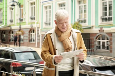 Yakışıklı olgun adam açık havada gazete okuma