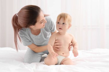 Genç anne ve şirin bebeği evde yatakta