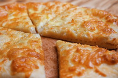 Lezzetli khachapuri ahşap plaka üzerinde closeup kesti.